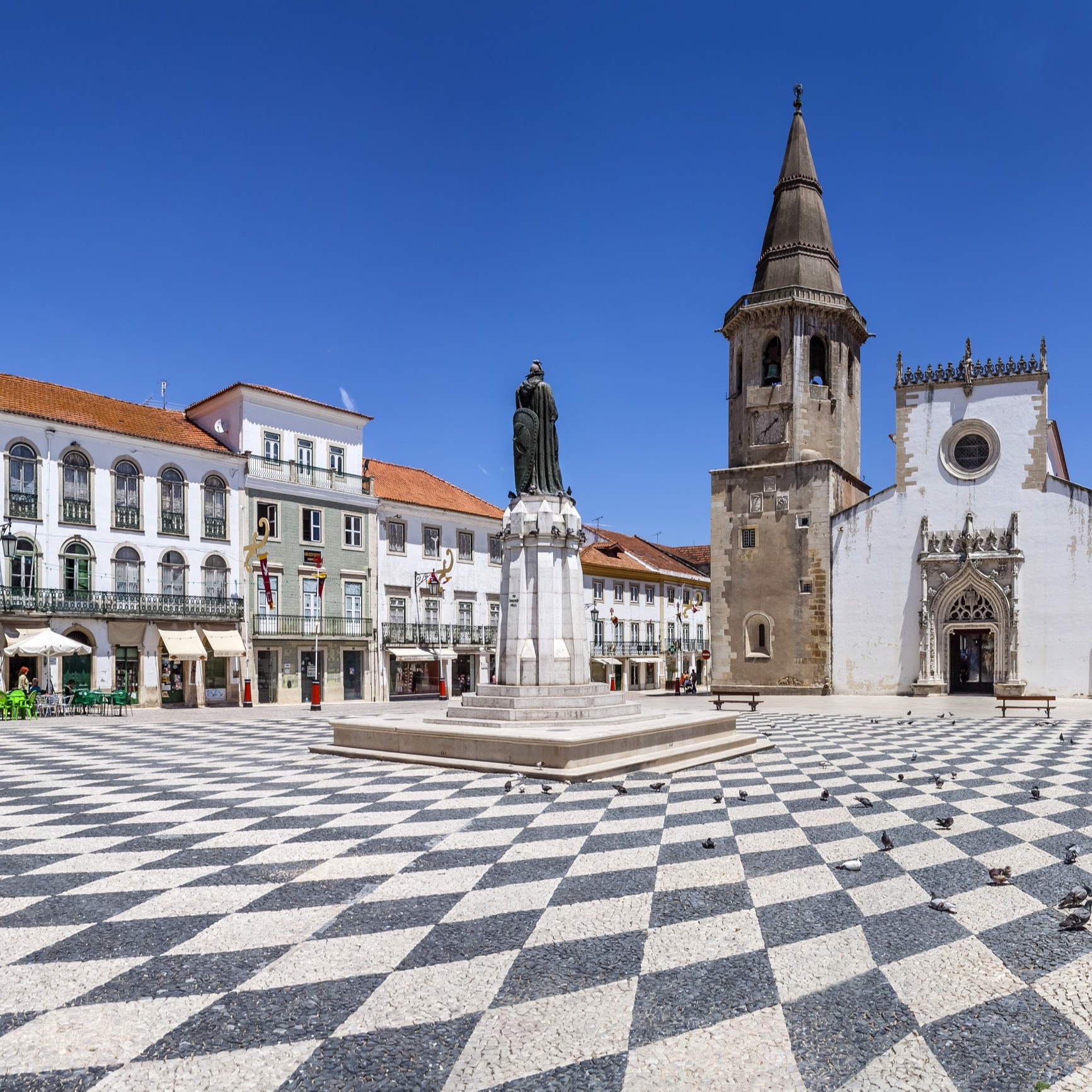 Enquadramento Cénico - A Igreja apresenta uma planta retangular, estruturada em três naves e com uma torre sineira com um relógio do século XVI. Os seus portais são luxuosamente decorados ao estilo manuelino.